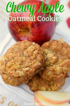 two oatmeal cookies are on a plate with an apple in the background