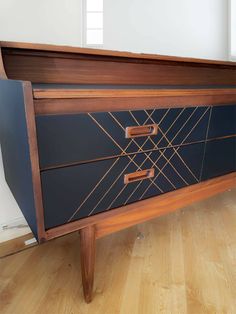 a wooden dresser with two drawers on the front and one drawer closed up to reveal an interesting design