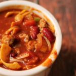 a white bowl filled with chili and meat