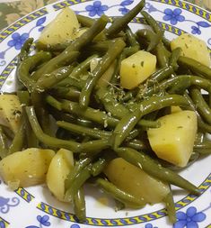 green beans and potatoes on a blue and white plate with yellow trim around the edges