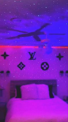 a bed in a room with purple lights and stars on the ceiling, along with wall decorations