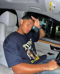 a man sitting in the back seat of a car with his hand on his head