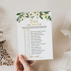 a hand holding up a printable wedding checklist with flowers on it and the words ever or never written in gold