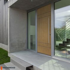 an entrance to a modern house with glass doors