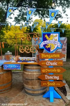 an outdoor bar with wooden barrels and signs