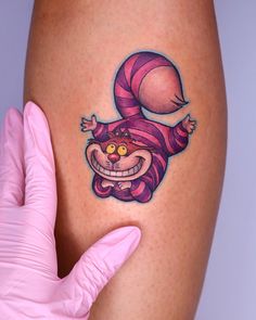 a woman's thigh with a cartoon character tattoo on it and a pink glove