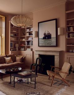 a living room filled with furniture and a fire place in front of a large window