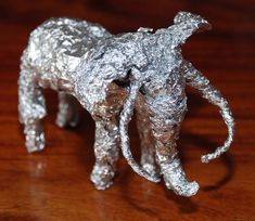 an elephant made out of tin foil on a table