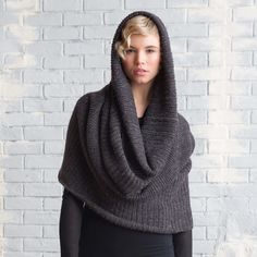 a woman wearing a gray knitted shawl