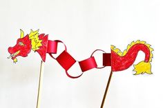 two toothpicks decorated with red and yellow paper