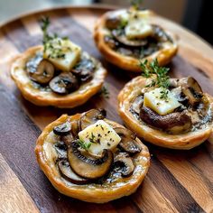 small pastries with mushrooms and cheese on a wooden plate