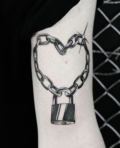 a heart shaped lock and chain tattoo on the arm