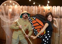 a man and woman dressed up in costumes posing for a photo with a butterfly net