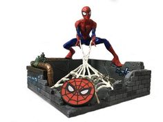 a spider - man statue sitting on top of a brick wall