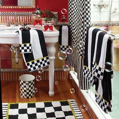 a bathroom with black and white checkered rugs on the floor next to a sink