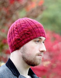 a man wearing a red knitted hat looking off into the distance