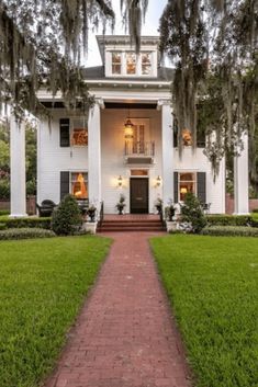 a large white house with trees and bushes