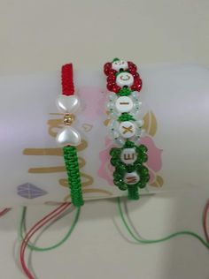 two bracelets made out of plastic beads and beaded with red, white and green beads