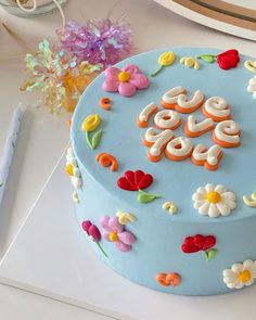 a blue cake decorated with flowers and the word love on it