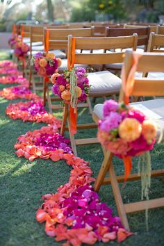 rows of wooden chairs lined up with flowers and ribbons on the back of each chair