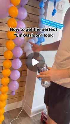 a person holding a water bottle in front of balloons