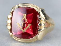 "This large vintage red glass Masonic ring has amazing, yet simply detailed shoulders, rising up from the shank and bending around the corners of the stone. The center is a classic red glass cabochon, inlaid with the gold Masonic symbol, with a nice flat profile. This ring has a substantial feel to it, and makes for a classic Masonic piece! Metal: 14K Yellow Gold Gem: Red Glass Cabochon, Gold Inlaid Masonic Symbol Gem Measures: 16mm x 14mm, Square Cushion Cut Size of Ring: 10 Marks: \"14K\" and Masonic Symbol, Masonic Symbols, Masonic Ring, Best Flats, Red Glass, Cushion Cut, Signet Ring, Gemstone Rings, Gems