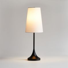 a black table lamp with a white shade on the base and a light bulb at the end