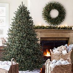 two christmas trees in wicker baskets next to a fireplace