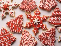 christmas cookies decorated with red and white icing are arranged on a table in the shape of snowflakes