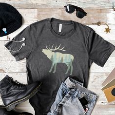 "All orders placed after December 12th cannot be guaranteed to be delivered before Christmas. Thank you very much for your business and Merry Christmas!! ** Nature Elk Shirt, Nature Shirt, Wildlife TShirt, Elk Bugling, Outdoors T-Shirt, Trees Tee, Nature Scene, Wyoming, Virginia, Montana, Utah, Yellowstone, Yosemite, Canada, Alaska, Kentucky, Arizona, California, Colorado, Washington, Oregon, Nevada, New Mexico, Utah, Mens Shirt, Womens Shirt ---- How To Order ----- 1-) Please, check and review all the photos. 2-) Choose your t-shirt size and color. 3-) Click add to cart. You can go back to add more shirts. 4-) Click \"Proceed to check out\". --- Unisex Sizes --- This classic unisex jersey short sleeve tee fits like a well-loved favorite. Soft cotton and quality print make users fall in lo Tee Tree, Nature Shirts, Solid Black, Wyoming, Fabric Material, New Mexico, Nevada, Jersey Shorts, Montana