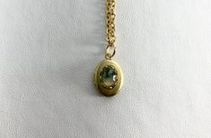 This sweet, small, OVAL antique brass locket has a faceted Moss Agate cabochon set on the front.  The cabochon sits in a brass lace edged setting. It hangs on a 16" gold-plated stainless-steel chain necklace.  The locket is approximately 11x16mm.  The cabochon is 5x7mm.  Arrives in an eco-friendly jewelry box, ready for gifting. MORE lockets in my shop! FREE SHIPPING! THANK YOU FOR VISITING MY SHOP! Stainless Steel Chain Necklace, Agate Cabochon, Eco Friendly Jewelry, Lace Edging, Locket Necklace, Moss Agate, Steel Chain, Stainless Steel Chain, Locket