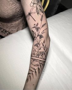 a woman's arm with flowers and dragonflys on the back of her leg