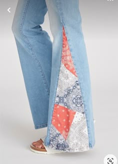 a woman's jeans with an orange and white patchwork design