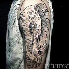 an elephant and fish tattoo on the arm