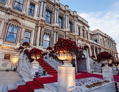 an elaborately decorated building with red flowers on the steps