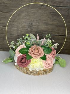 a cake with flowers and greenery in the shape of a circle on top of a table