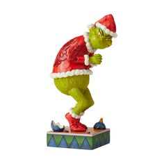 a statue of a green creature wearing a santa hat