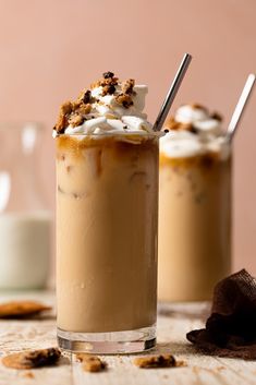 two glasses filled with ice cream and topped with marshmallows on a table