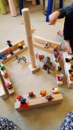 a child playing with wooden toys on the floor