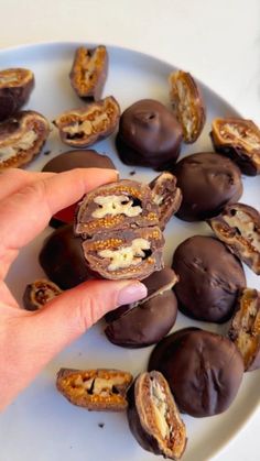 someone is holding up some chocolates on a plate