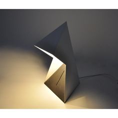 a lamp that is sitting on top of a table next to a white wall and floor