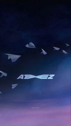 several white paper airplanes flying in the sky at night with purple and blue clouds behind them