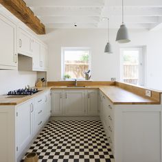 a kitchen with black and white checkered flooring next to a stove top oven