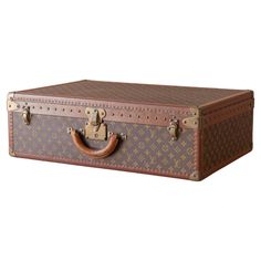 Louis Vuitton large ‘Alzer’ suitcase in LV monogram pattern coated canvas with edges trimmed in lozine and unpolished brass fittings. The lid of the case is secured by a central sprung catch with lock, plus two additional latches. Cream coated canvas lining to the interior and a removable tray with two fabric straps. Circa 1995. Dimensions: 70 cm/ 28 inches (width) x 47cm/ 18 inches (depth) x 22cm/ 9 inches (height). Louis Vuitton was founded by its namesake in 1854, with the first shop on Rue N Louis Vuitton Luggage, Cream Coat, Color Crema, Monogram Pattern, S Monogram, Lv Monogram, Brass Fittings, Coat Patterns, Luxury Travel