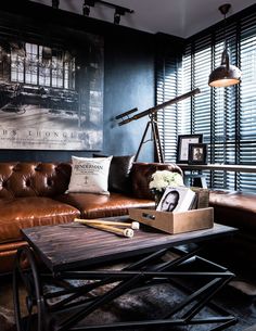 a living room with leather couches and pictures on the wall