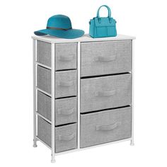 a white dresser with drawers and a blue hat on top