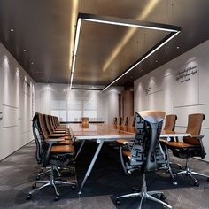 an empty conference room with chairs and a large boardroom table in front of it