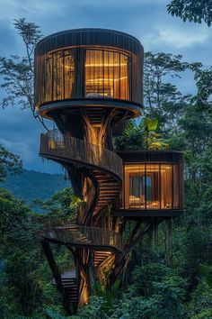 an unusual tree house in the middle of the forest with stairs leading up to it