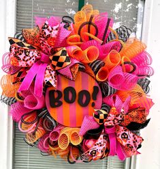 a halloween wreath with the word boo on it and orange, black, and pink bows