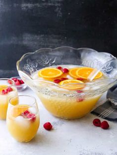 three glasses filled with orange juice and garnished with cranberries on a table